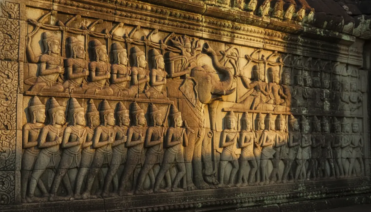 Detailed bas-relief carvings at Angkor Wat temple showing ancient Khmer art